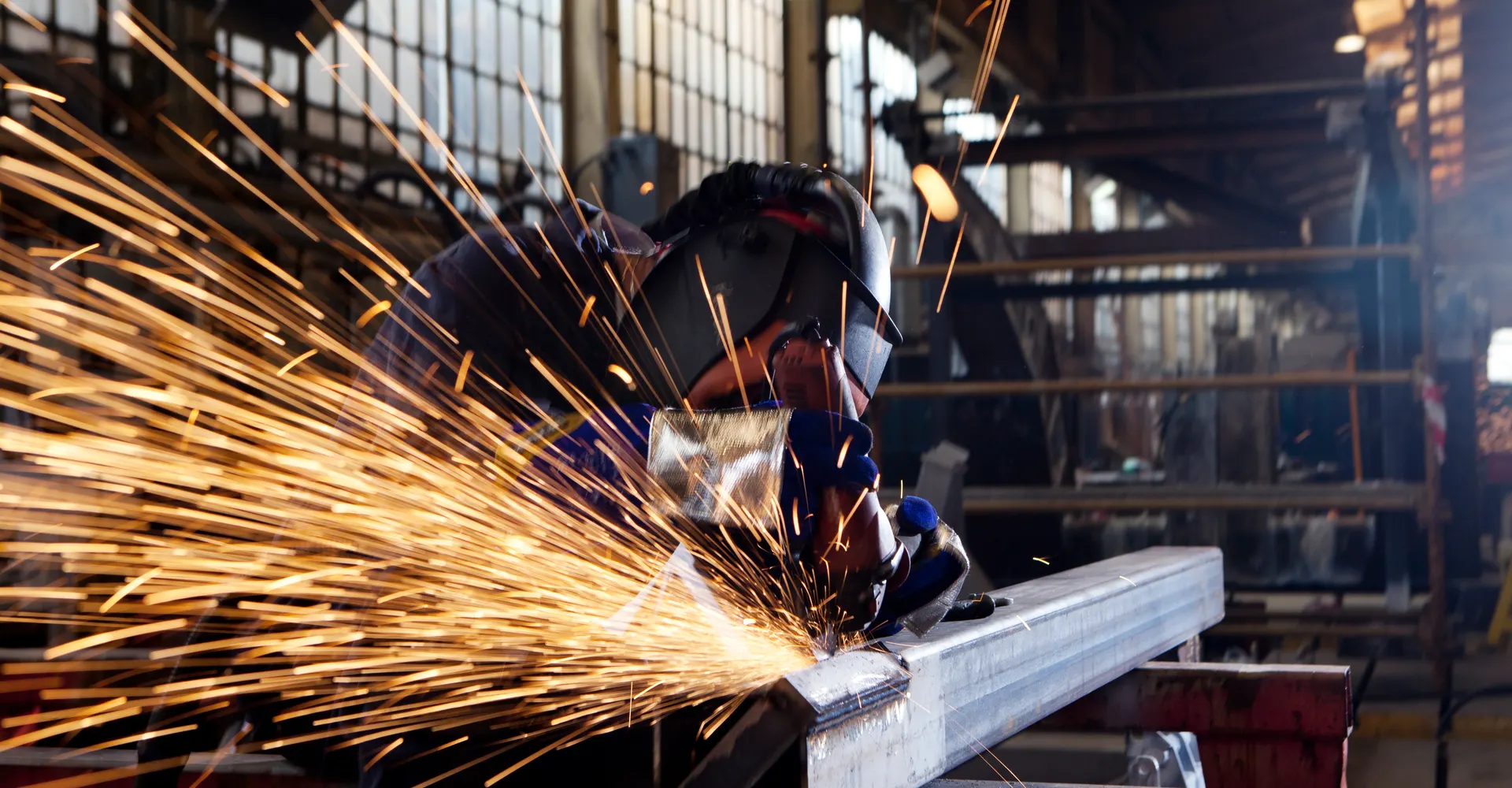 Worker using a grinder inside the fabrication shop