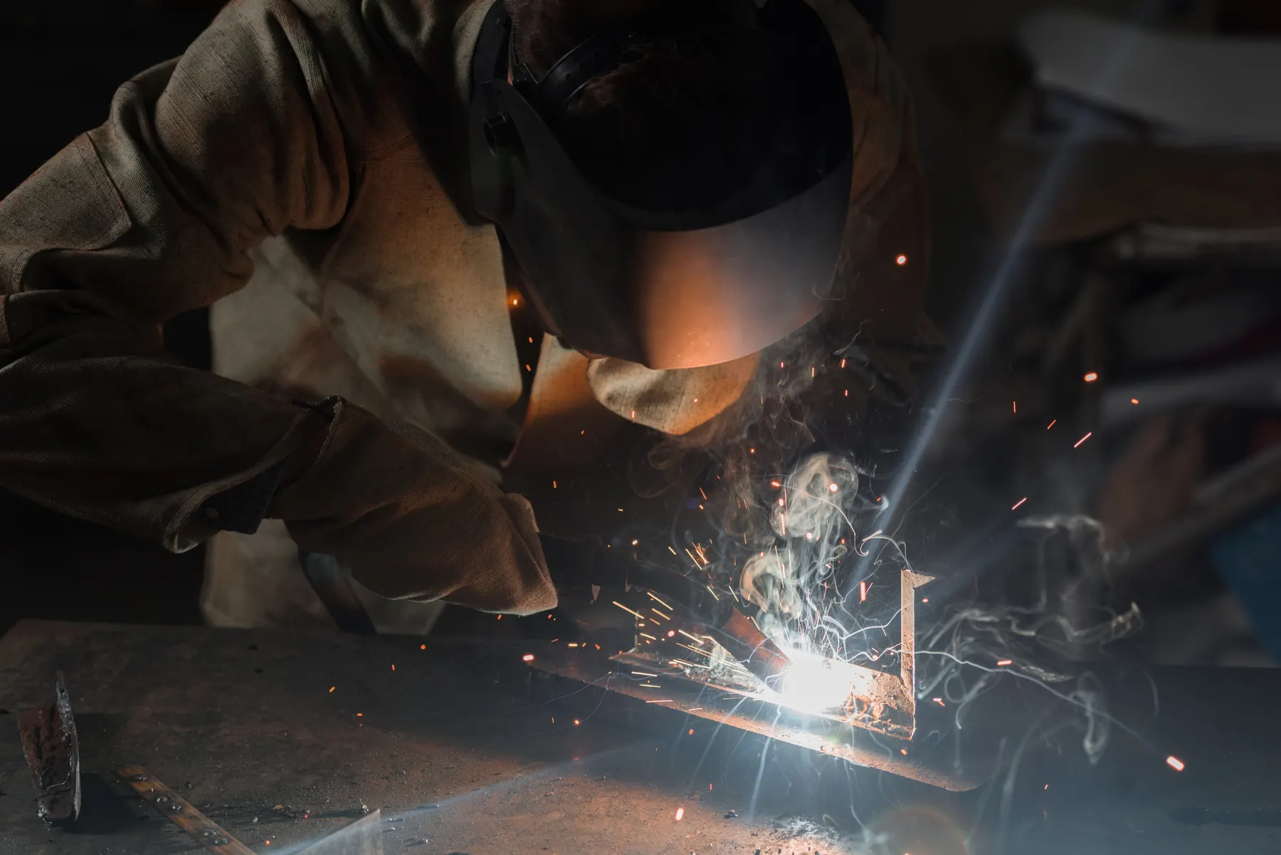 Welder at work with sparks in the shop